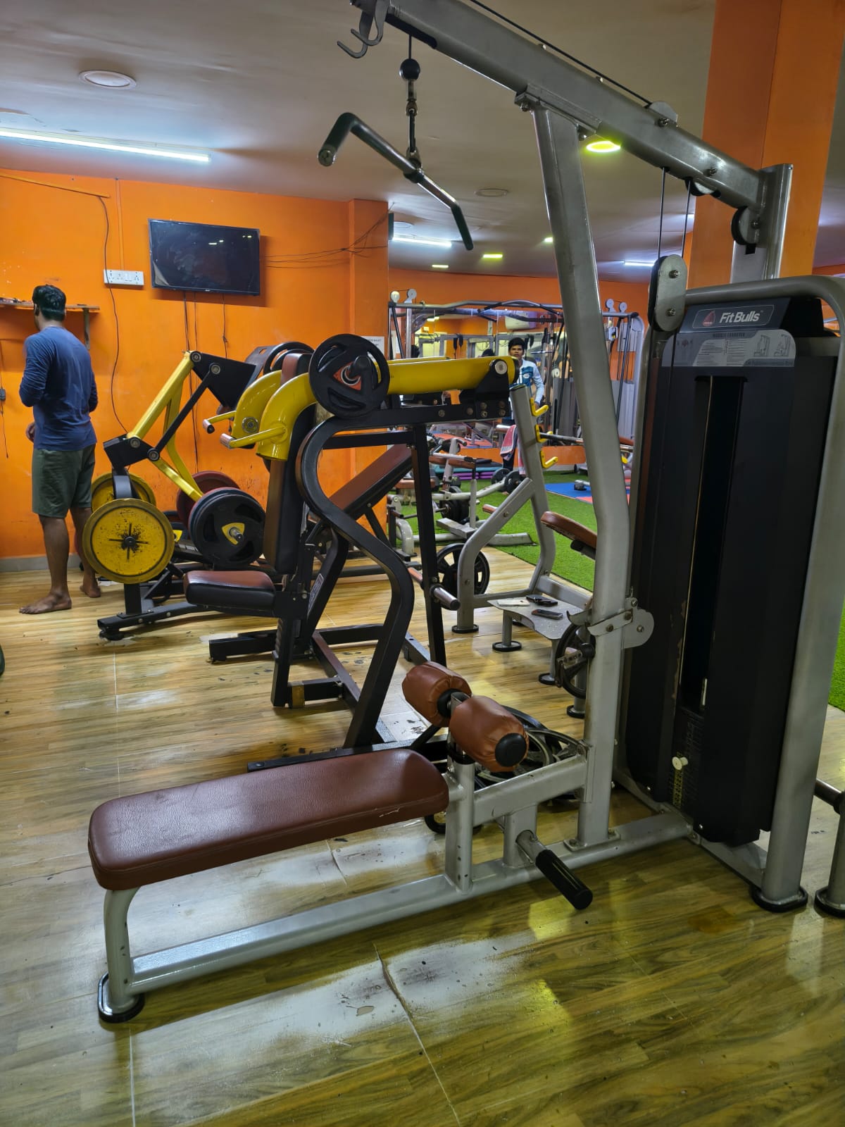Lat pulldown and low row station at Shree Fitness, with plate-loaded machines behind